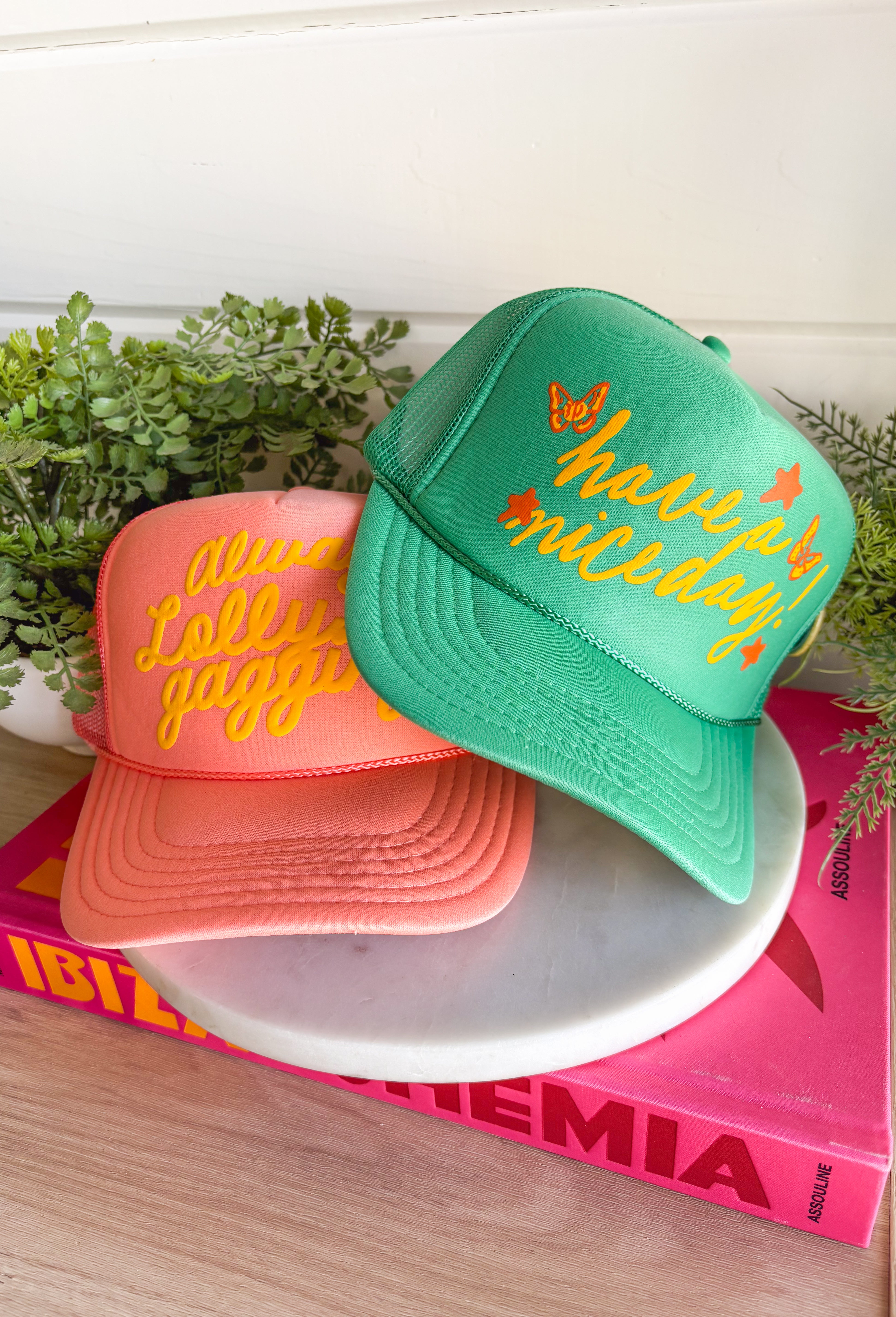All the good vibes in one hat! This green trucker hat features “Have A Nice Day!” in a warm mustard tone, surrounded by playful orange and mustard butterflies and star details for the happiest little pop of personality. A small yellow button on the side that reads “Sorry Out of Office” adds a fun, laid-back touch that makes this hat even more unique. With a breathable mesh backing and adjustable fit, it’s perfect for sunny days, weekend plans, or anytime you're in your carefree era.
