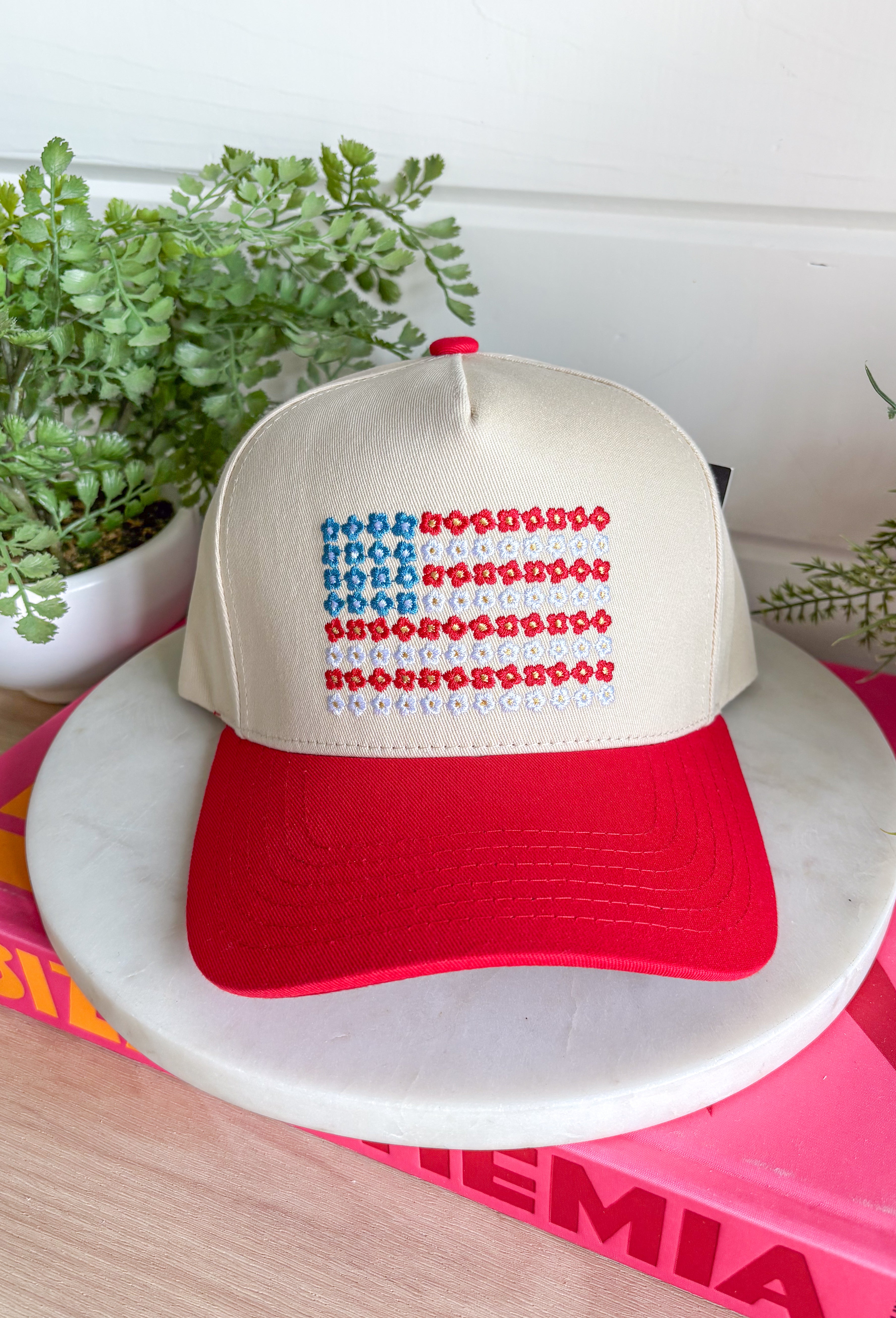 This neutral trucker hat with a red bill is the cutest way to show off your patriotic spirit this summer! The embroidered red, white, and blue floral design creates a unique American flag look that feels both festive and feminine. It’s perfect for the 4th of July, backyard BBQs, lake days, and all your sunny celebrations. With a adjustable fit, it’s as comfortable as it is eye-catching. 