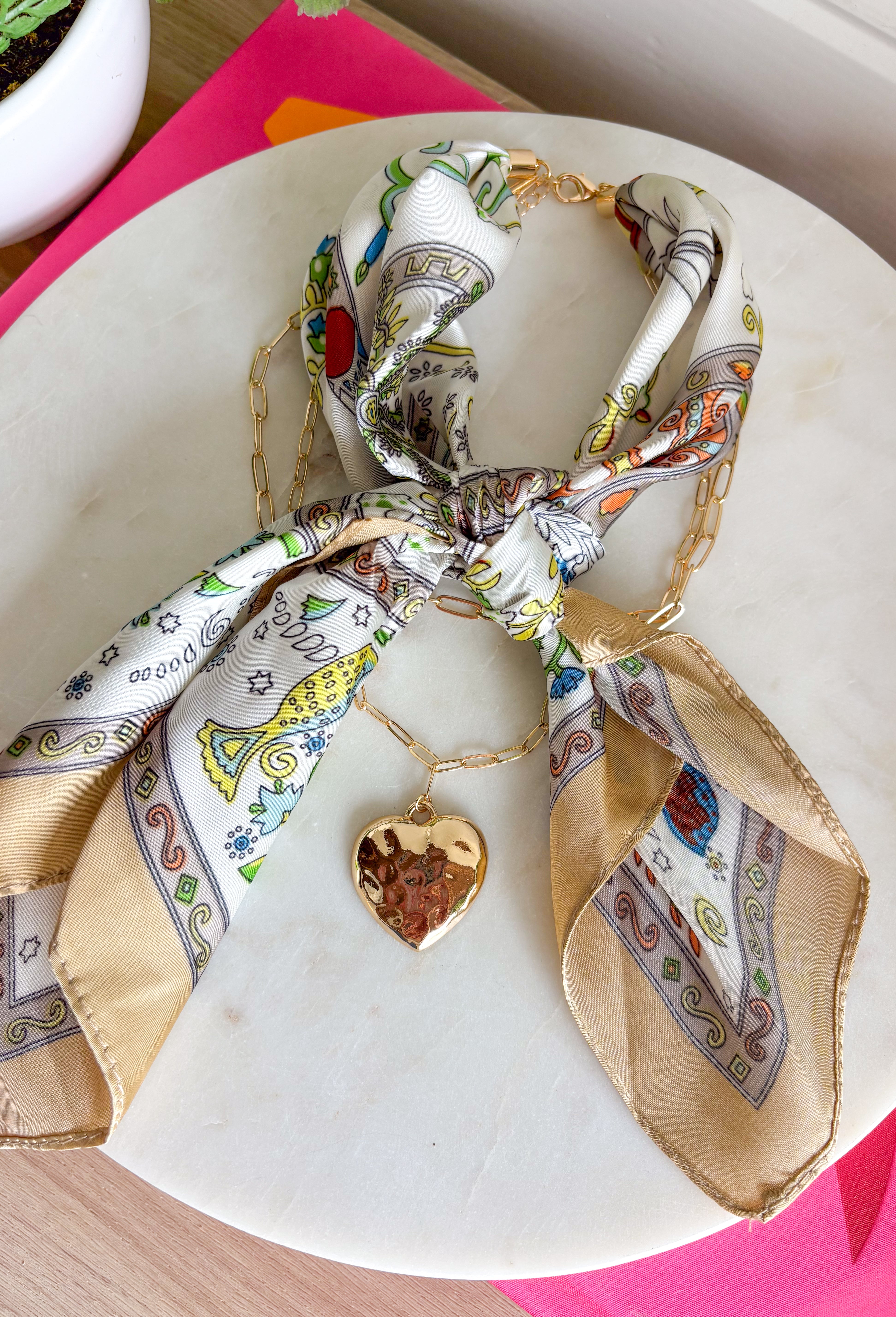 This neck scarf necklace set is the ultimate trendy, throw-on-and-go accessory for summer! Featuring a neutral abstract print scarf paired with a gold textured heart necklace and a dainty gold chain, it gives you that perfectly layered look with zero effort. It’s such a fun way to elevate even your simplest outfits—just add it to a tank or dress and you’re instantly styled. Lightweight and easy to wear, this piece brings a mix of chic and playful that feels so current. 