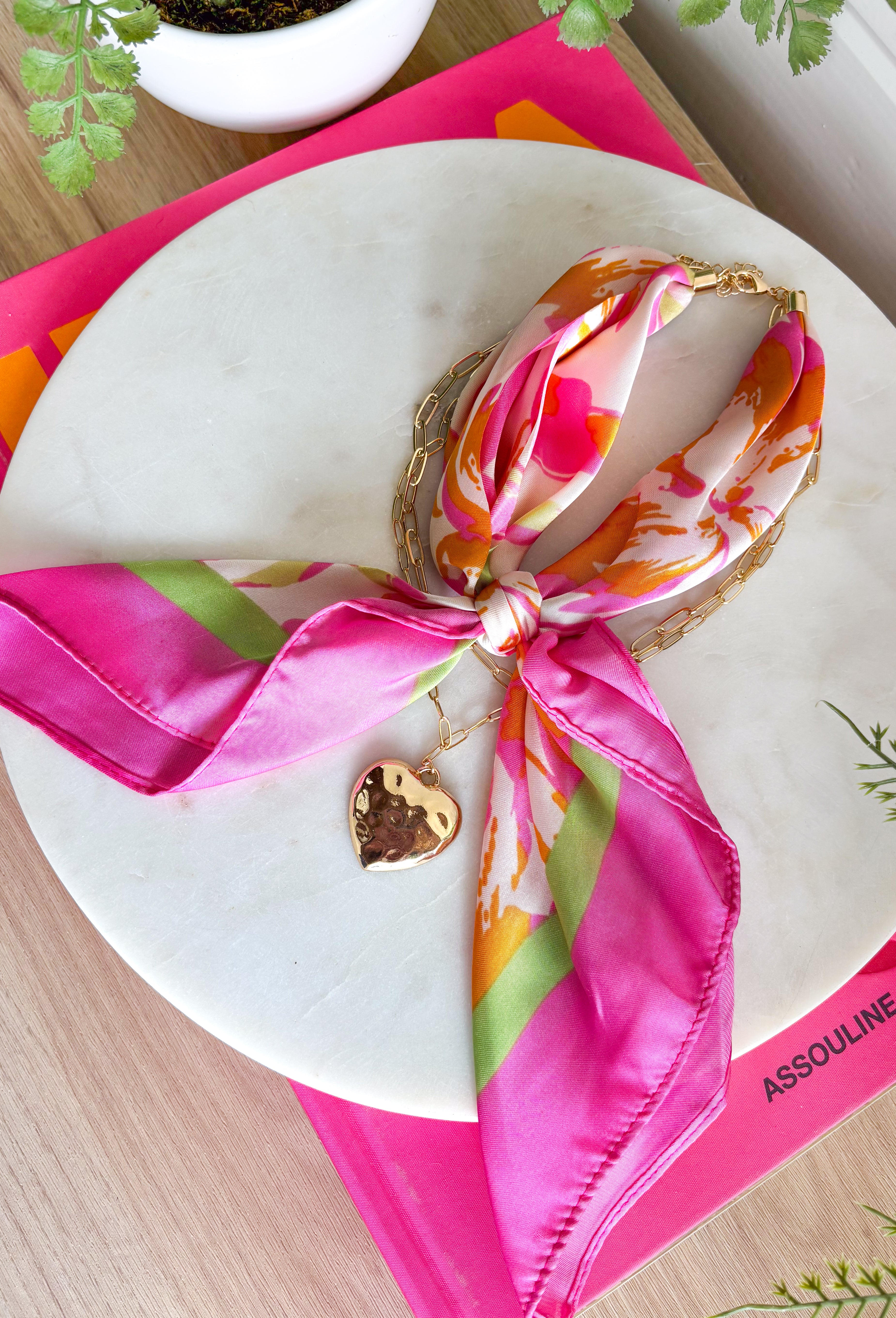This neck scarf necklace set is the ultimate trendy, throw-on-and-go accessory for summer! Featuring a colorful abstract print scarf paired with a gold textured heart necklace and a dainty gold chain, it gives you that perfectly layered look with zero effort. It’s such a fun way to elevate even your simplest outfits—just add it to a tank or dress and you’re instantly styled. Lightweight and easy to wear, this piece brings a mix of chic and playful that feels so current. 