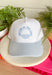This trucker hat was made for sunny lake days and summer weekends! Featuring "Better At The Lake" embroidered across the front in light blue with a cute water design, it’s the perfect accessory for all your warm-weather adventures. The white crown paired with the blue, white, and off white striped bill gives it a fresh, coastal-inspired feel that looks just as good on the boat as it does grabbing lunch by the water. It’s an easy grab-and-go favorite you'll wear all season long. 