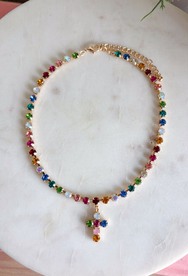 Add a meaningful touch of color to your jewelry collection with this beautiful cross necklace. Featuring a strand of colorful rhinestone crystals in shades of red, blue, green, pink, and gold, this eye-catching piece is finished with a matching cross pendant for the perfect blend of faith and style. The vibrant colors and delicate gold accents make it a standout accessory that's easy to wear for both everyday outfits and special occasions.