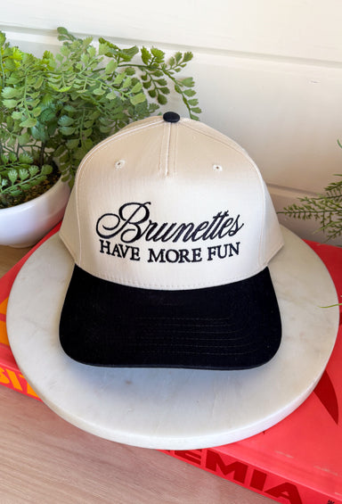 This trucker hat is bringing the attitude—in the best way! Featuring “Brunettes Have More Fun” embroidered across the front, it’s the perfect mix of playful and a little bold. The tan base with a black bill keeps it easy to style, while the statement graphic does all the talking. Whether you're heading out for errands, a casual day with friends, or just embracing your brunette era, this hat adds that fun finishing touch. 