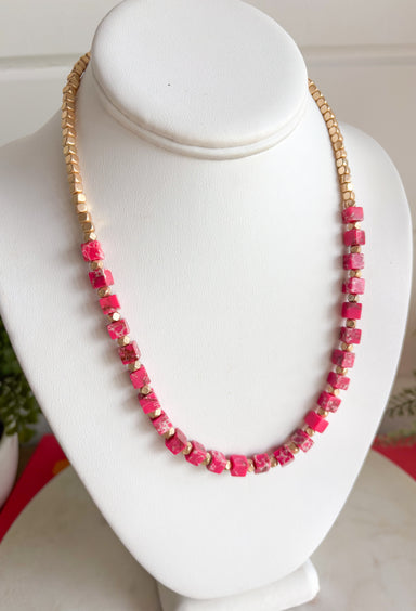 This matte gold and pink beaded necklace is the perfect little pop of color your summer outfits have been waiting for! The mix of square matte gold beads and pink accents gives it a fun, trendy feel while still being easy to style every day. Lightweight and eye-catching, it layers beautifully or stands out on its own with your favorite tanks and dresses. 