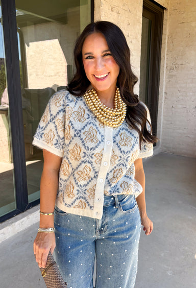 Give your fall layers a vintage-inspired update with this soft short sleeve cardigan from & Merci. The mix of muted denim blue, warm camel, and ivory creates a cozy, lived-in color palette that feels right at home with your favorite autumn outfits. A button-down front makes it easy to wear closed as a top or open over a simple tank for a layered look. Soft and comfortable with just the right amount of stretch, this printed cardigan is an easy statement piece.