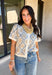 Give your fall layers a vintage-inspired update with this soft short sleeve cardigan from & Merci. The mix of muted denim blue, warm camel, and ivory creates a cozy, lived-in color palette that feels right at home with your favorite autumn outfits. A button-down front makes it easy to wear closed as a top or open over a simple tank for a layered look. Soft and comfortable with just the right amount of stretch, this printed cardigan is an easy statement piece.