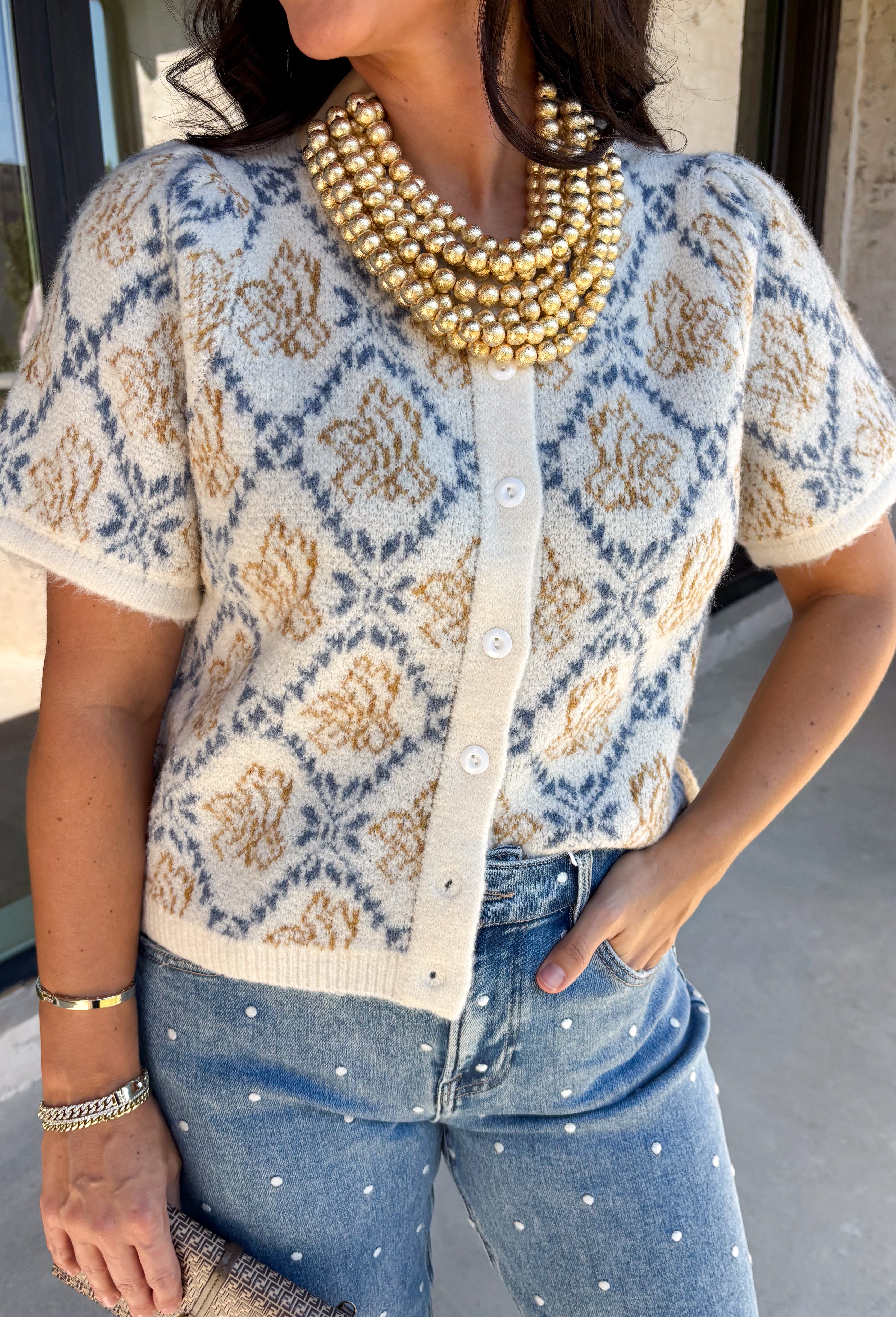Give your fall layers a vintage-inspired update with this soft short sleeve cardigan from & Merci. The mix of muted denim blue, warm camel, and ivory creates a cozy, lived-in color palette that feels right at home with your favorite autumn outfits. A button-down front makes it easy to wear closed as a top or open over a simple tank for a layered look. Soft and comfortable with just the right amount of stretch, this printed cardigan is an easy statement piece.