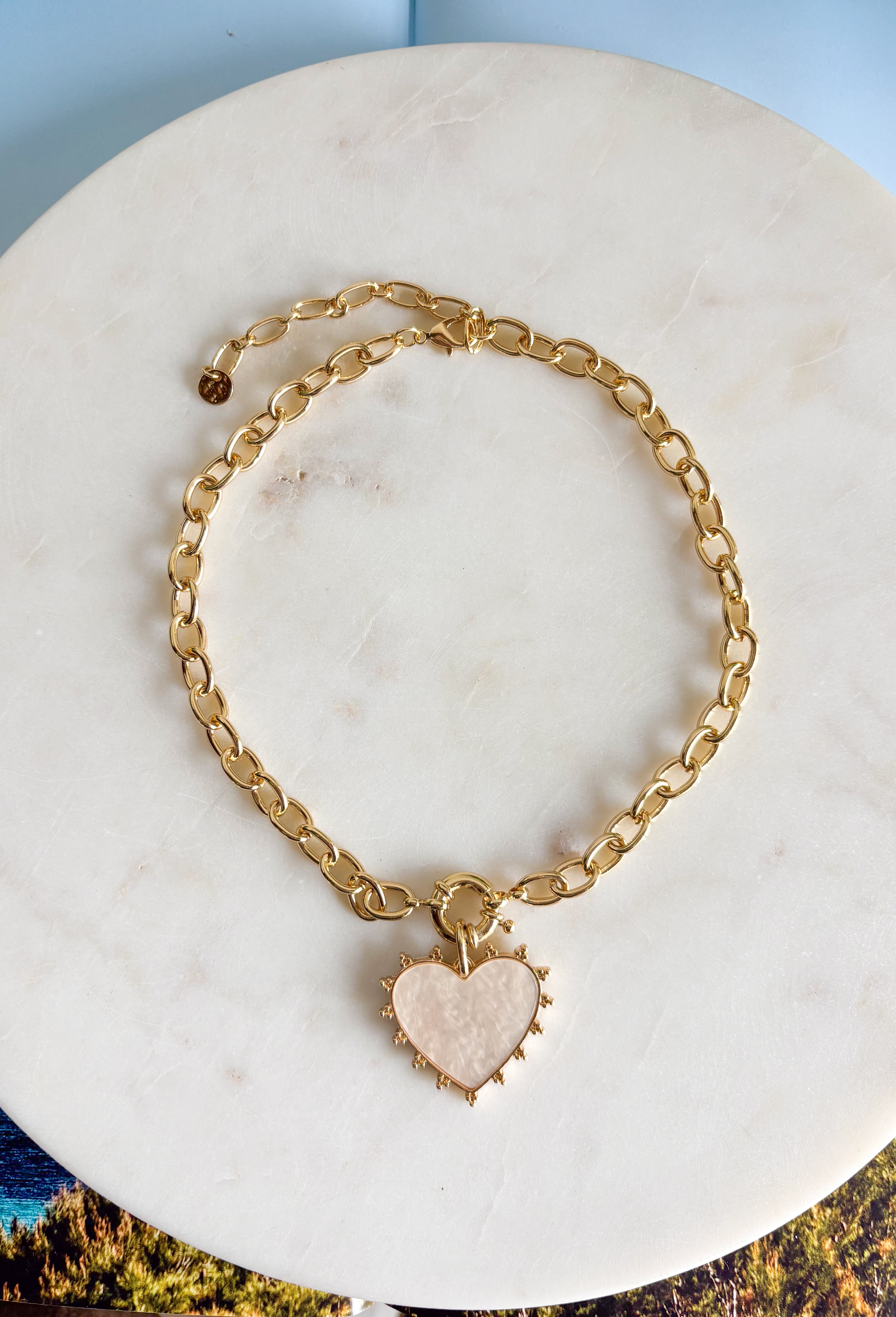 Elegant with a soft, feminine glow! This gold open chain link necklace features a beautiful mother of pearl heart pendant outlined in polished gold for a timeless look. The natural shimmer of the pearl gives the piece a delicate, luminous finish that feels both classic and modern. The open link chain adds a stylish touch while keeping the design easy to wear and versatile. 