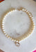 Elegant, timeless, and effortlessly versatile, this ivory beaded necklace is the perfect accessory to elevate any outfit. Featuring beautiful ivory beads, this classic piece is accented with a dazzling crystal rhinestone charm that adds just the right amount of shimmer. Whether you're dressing up a cozy sweater, styling your favorite blouse, or adding a polished finishing touch to a special occasion look, this necklace is one you'll reach for season after season.