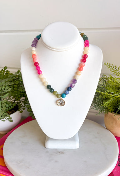 Bright, playful, and full of personality, this colorful beaded necklace is the perfect finishing touch for any outfit. Featuring vibrant multicolored beads, this cheerful accessory is accented with a dazzling crystal rhinestone charm that catches the light beautifully. Whether you wear it on its own as a statement piece or layer it with your favorite gold chains, this necklace adds the perfect pop of color and shine to every look.