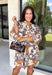 Celebrate the beauty of the season with this effortlessly feminine dress from Entro. Designed with a soft ecru backdrop and a gorgeous floral print in shades of tan, brown, and blue, this timeless dress is perfect for everything from brunch dates to family gatherings. The flattering v-neck collar detail creates a polished look, while the ¾ puff sleeves add a touch of romantic charm.