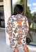 Celebrate the beauty of the season with this effortlessly feminine dress from Entro. Designed with a soft ecru backdrop and a gorgeous floral print in shades of tan, brown, and blue, this timeless dress is perfect for everything from brunch dates to family gatherings. The flattering v-neck collar detail creates a polished look, while the ¾ puff sleeves add a touch of romantic charm.