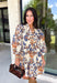 Celebrate the beauty of the season with this effortlessly feminine dress from Entro. Designed with a soft ecru backdrop and a gorgeous floral print in shades of tan, brown, and blue, this timeless dress is perfect for everything from brunch dates to family gatherings. The flattering v-neck collar detail creates a polished look, while the ¾ puff sleeves add a touch of romantic charm.