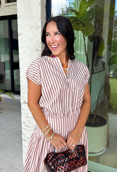 Add a fresh twist to your fall wardrobe with this light pink striped top from Day + Moon. The warm brown stripe print gives the soft pink color an autumn-ready feel, while the front zipper adds a fun, modern detail. Elastic at the hem and sleeves creates a comfortable shape that's easy to wear throughout the day. Pair it with the matching midi skirt for a coordinated two-piece set, or style it on its own with your favorite denim or chocolate brown bottoms.
