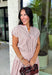 Add a fresh twist to your fall wardrobe with this light pink striped top from Day + Moon. The warm brown stripe print gives the soft pink color an autumn-ready feel, while the front zipper adds a fun, modern detail. Elastic at the hem and sleeves creates a comfortable shape that's easy to wear throughout the day. Pair it with the matching midi skirt for a coordinated two-piece set, or style it on its own with your favorite denim or chocolate brown bottoms.