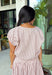 Add a fresh twist to your fall wardrobe with this light pink striped top from Day + Moon. The warm brown stripe print gives the soft pink color an autumn-ready feel, while the front zipper adds a fun, modern detail. Elastic at the hem and sleeves creates a comfortable shape that's easy to wear throughout the day. Pair it with the matching midi skirt for a coordinated two-piece set, or style it on its own with your favorite denim or chocolate brown bottoms.