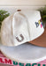 A little reminder to appreciate the good stuff! This neutral trucker hat from Etta &amp; East features colorful embroidered “How Lucky Are We” lettering across the front for a playful pop against the classic neutral design. A rich brown bill gives it an autumn-ready feel, while an embroidered horseshoe on the side adds an extra lucky touch. Finished with an adjustable fit, it’s an easy grab-and-go accessory for football weekends, coffee runs, road trips, and everyday errands.