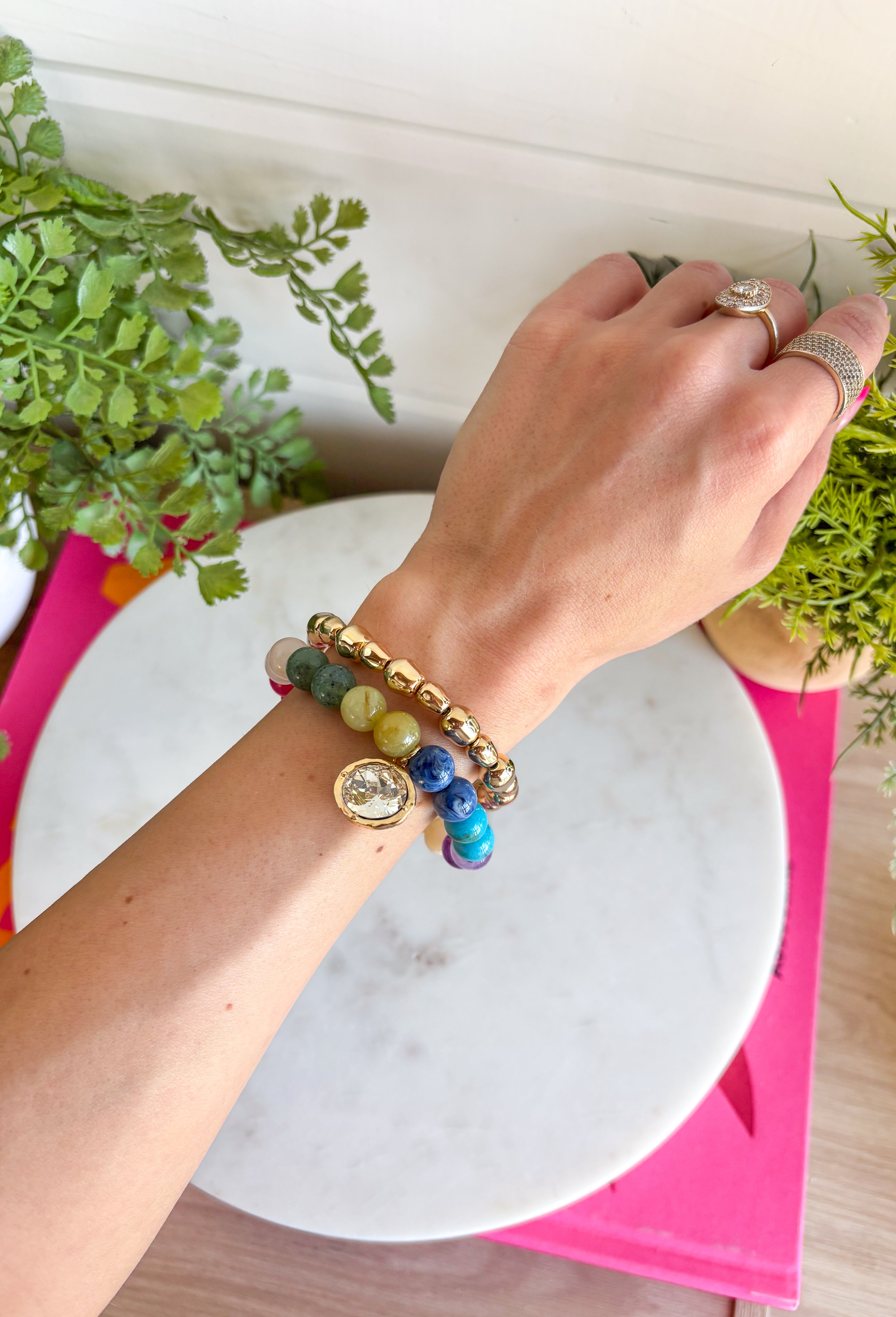 The easiest way to add a fun pop of color to your everyday look! This set of two pull-on bracelets is designed for effortless styling, featuring one colorful beaded bracelet with a sparkling crystal charm embellishment and one classic gold beaded bracelet. Wear them together for a perfectly layered look, or style each one on its own to complement any outfit. 