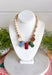 Neutral meets statement-making color with this eye-catching beaded necklace. A neutral beaded strand is accented with larger stone details across the front in rich brown, olive, fuchsia, and light blue, creating a playful mix of earthy and colorful tones. Gold beading between the stones adds a touch of shine and helps each color stand out. It’s the perfect piece when you want an accessory that’s easy to wear but still brings something extra to your outfit.