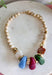Neutral meets statement-making color with this eye-catching beaded necklace. A neutral beaded strand is accented with larger stone details across the front in rich brown, olive, fuchsia, and light blue, creating a playful mix of earthy and colorful tones. Gold beading between the stones adds a touch of shine and helps each color stand out. It’s the perfect piece when you want an accessory that’s easy to wear but still brings something extra to your outfit.