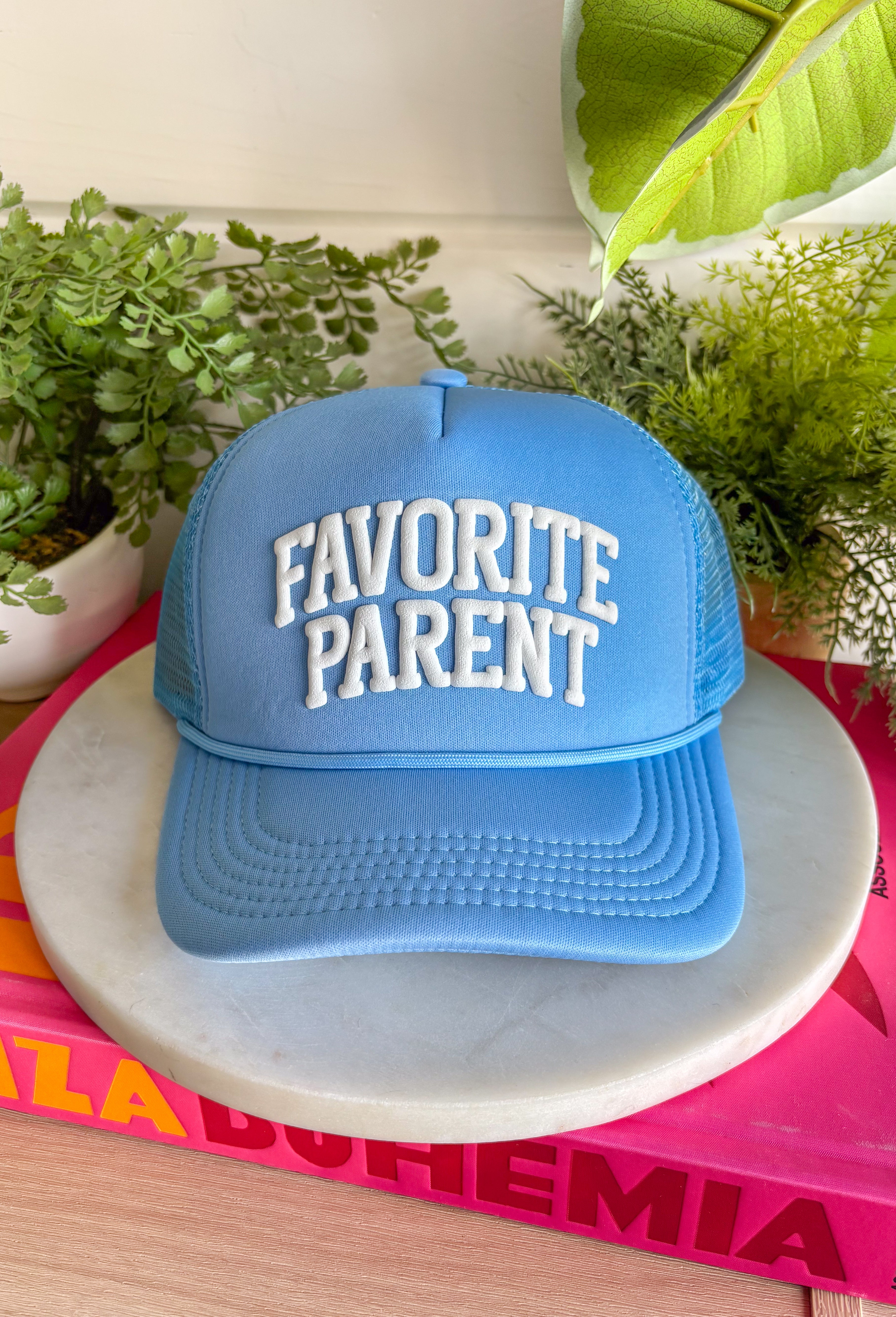 Claim the title loud and proud! This light blue trucker hat features “Favorite Parent” in bold white bubble letters for a playful, confident statement. It’s fun, lighthearted, and guaranteed to spark a few laughs at pickup line or the next family outing. The soft blue color keeps it fresh and easy to style, while the breathable mesh backing and adjustable fit make it comfortable for everyday wear.