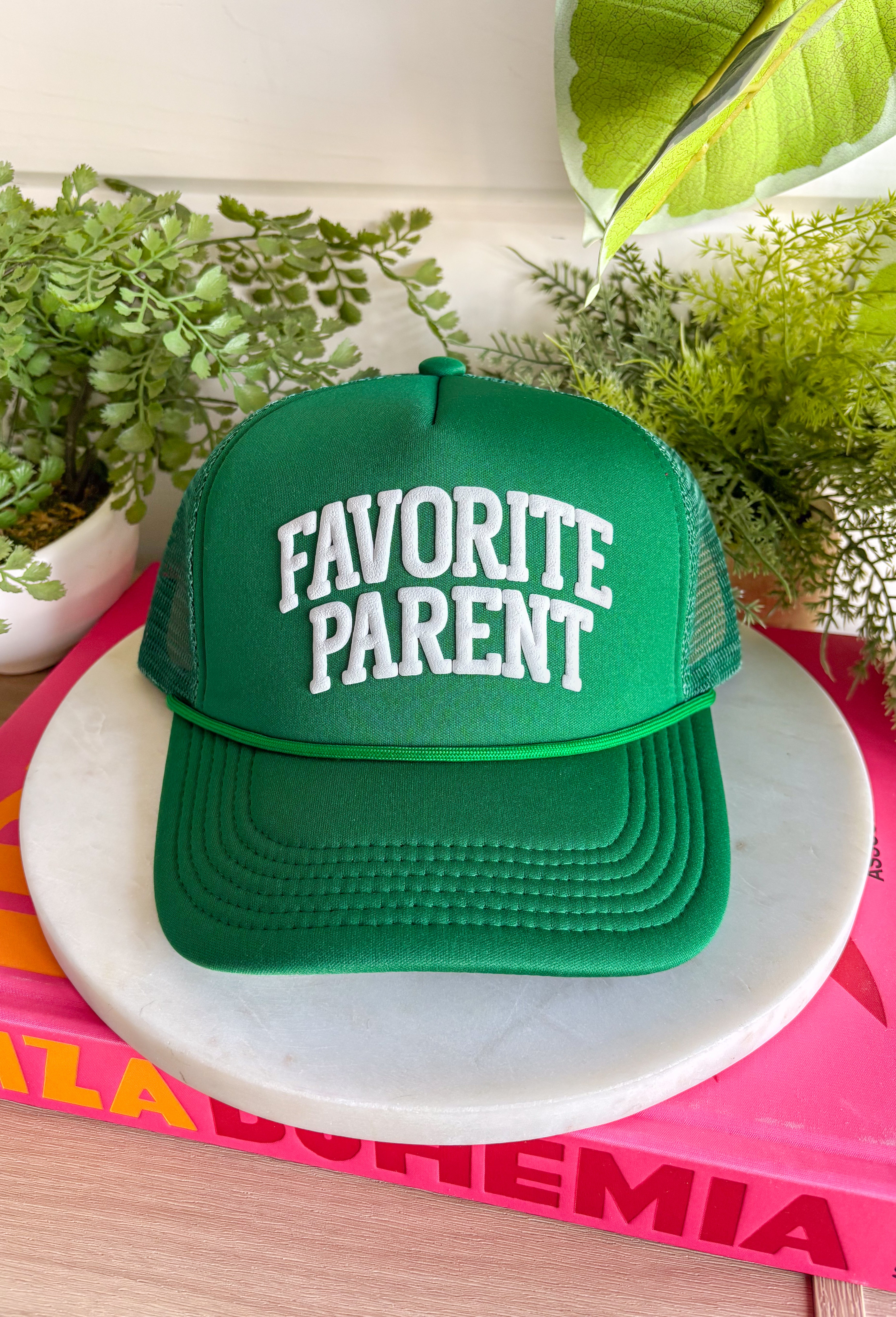 Claim the title loud and proud! This green trucker hat features “Favorite Parent” in bold white bubble letters for a playful, confident statement. It’s fun, lighthearted, and guaranteed to spark a few laughs at pickup line or the next family outing. The green color keeps it fresh and easy to style, while the breathable mesh backing and adjustable fit make it comfortable for everyday wear. 