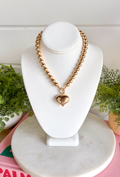 A classic gold necklace gets a sweet statement-making touch with this heart pendant design from Garden Party. Gold beading gives the necklace plenty of texture and shine, while the gold heart pendant creates a timeless focal point at the center. A toggle detail adds another eye-catching element and gives the piece a little extra personality. Easy to dress up or down, it’s the kind of necklace that works just as well with your everyday favorites as it does with dresses and special occasion looks.