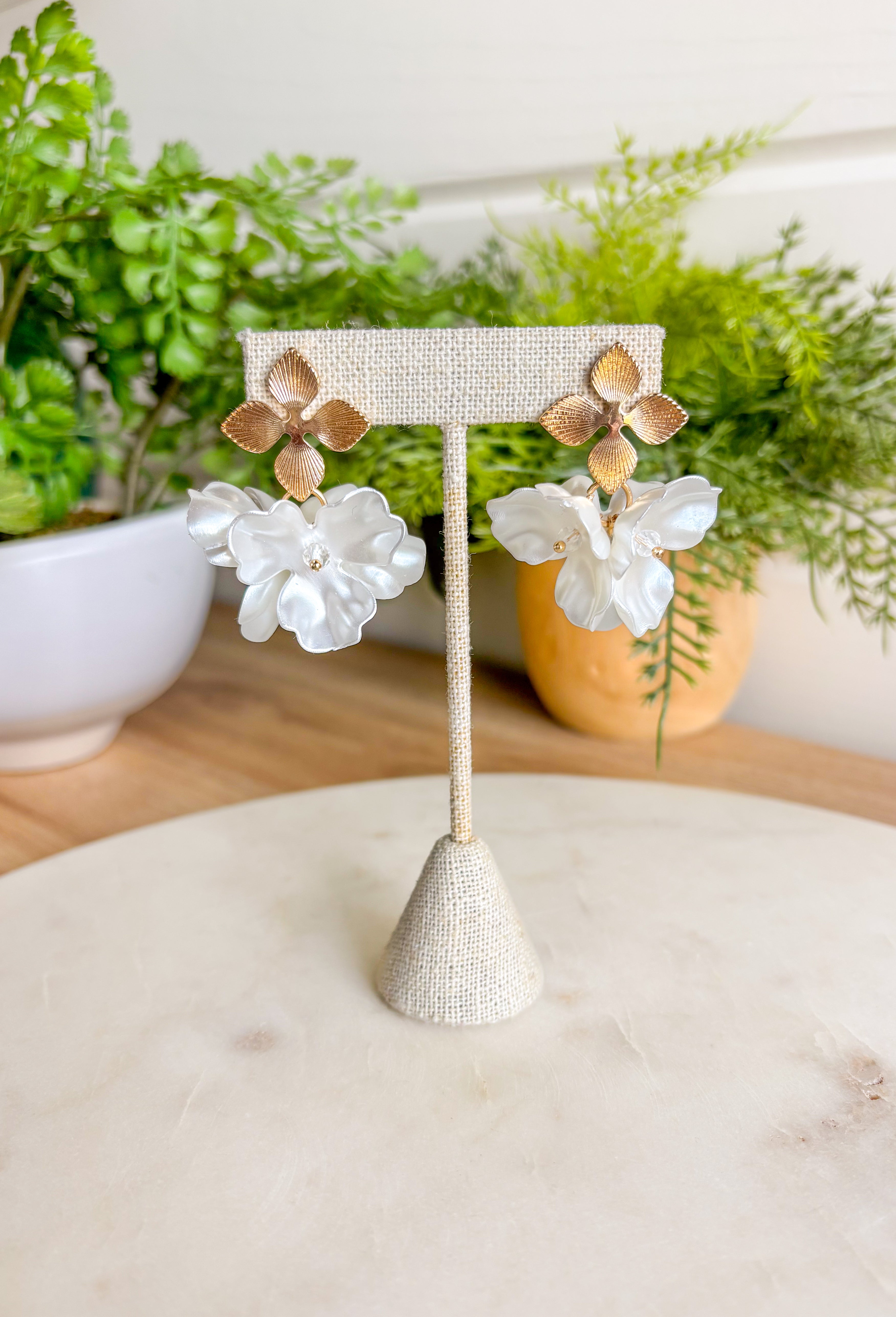 Designed with three stacked cream flowers and dainty bead detailing at the center of each, they’re the perfect touch of texture. Lightweight and effortless, they’re ready to elevate any outfit—whether you’re dressing up for brunch or keeping it casual in denim.&nbsp;