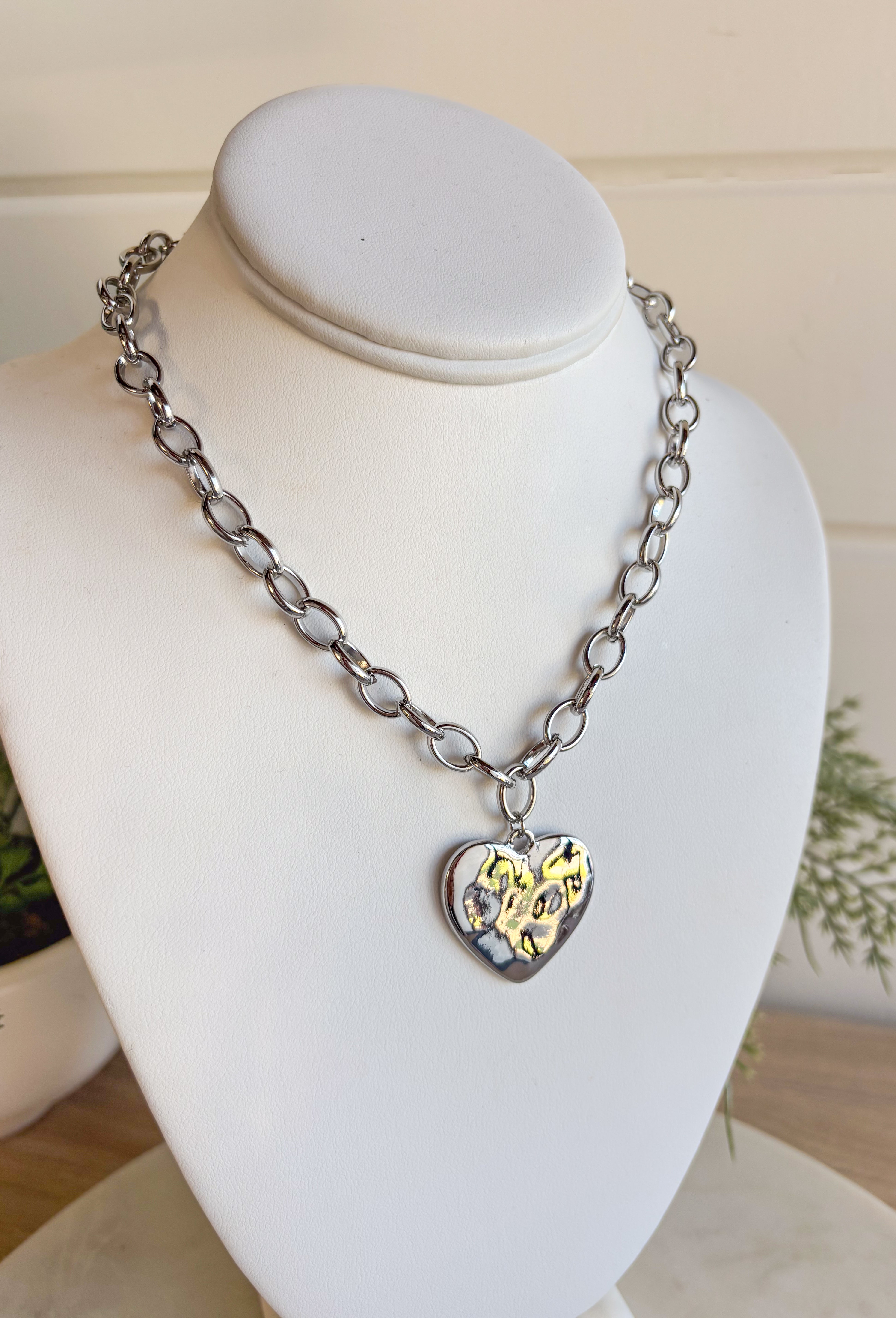 Simple, stylish, and oh-so versatile—this silver chain necklace is the perfect finishing touch for any look. Designed with a textured heart charm, it adds just the right amount of detail and personality without overpowering your outfit. With its adjustable extender, you can wear it closer to the neckline for layering or a little longer on its own. A timeless piece you’ll keep reaching for, no matter the occasion.