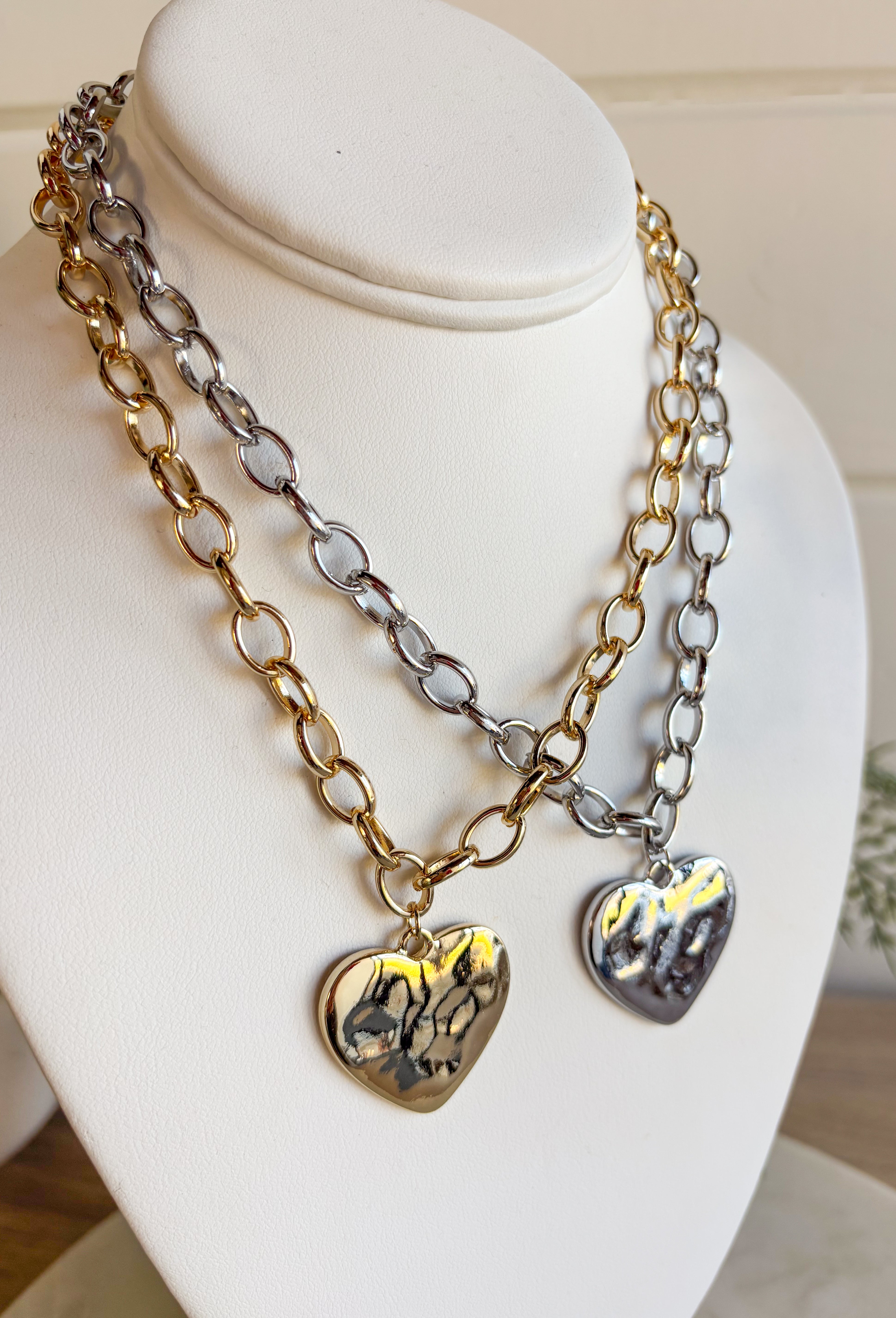 Simple, stylish, and oh-so versatile—this silver chain necklace is the perfect finishing touch for any look. Designed with a textured heart charm, it adds just the right amount of detail and personality without overpowering your outfit. With its adjustable extender, you can wear it closer to the neckline for layering or a little longer on its own. A timeless piece you’ll keep reaching for, no matter the occasion.