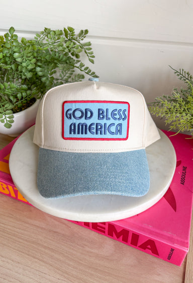 This neutral trucker hat with a denim bill and “God Bless America” patch is made for all your summer celebrations! Featuring a bold blue patch outlined in red, it brings the perfect patriotic touch—just in time for the 4th of July and beyond. The light wash denim bill adds a casual, laid-back feel, while the adjustable fit and breathable design keep it comfortable for all-day wear. Whether you're heading to fireworks, a backyard BBQ, or a lake day, this hat is the perfect finishing touch. 