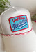This white trucker hat with red and white trim is the perfect finishing touch for all your summer celebrations! The bold blue patch outlined in red with “God Bless America” adds that classic patriotic feel, while the subtle trim detail along the bill gives it a fun, standout edge. Designed with a adjustable fit, it’s made for long days in the sun—from 4th of July festivities to lake days and backyard BBQs. It’s an easy grab-and-go accessory that instantly pulls your look together. 