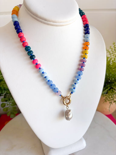 This colorful beaded necklace is the perfect accessory for adding a playful pop to your summer style! Featuring vibrant beads, a chic gold toggle clasp, and a pearl pendant charm, it combines trendy details with a timeless touch. The mix of color and pearl accents creates a fun, elevated look that's easy to wear with everything from casual tanks to breezy dresses. Whether you're heading on vacation, brunch with friends, or simply brightening up an everyday outfit, this necklace is sure to become a favorite.