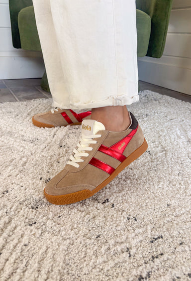 The Gola Elan Glitz sneakers bring a touch of shimmer to your classic casual style. Featuring rich metallic red tones against a caramel suede upper and a dark brown heel tab, this shoe strikes the perfect balance between sporty and chic. With its iconic wingflash design and luxe color palette, it’s an effortless choice for adding a little glam to your everyday look—whether you’re running errands or heading out for dinner.