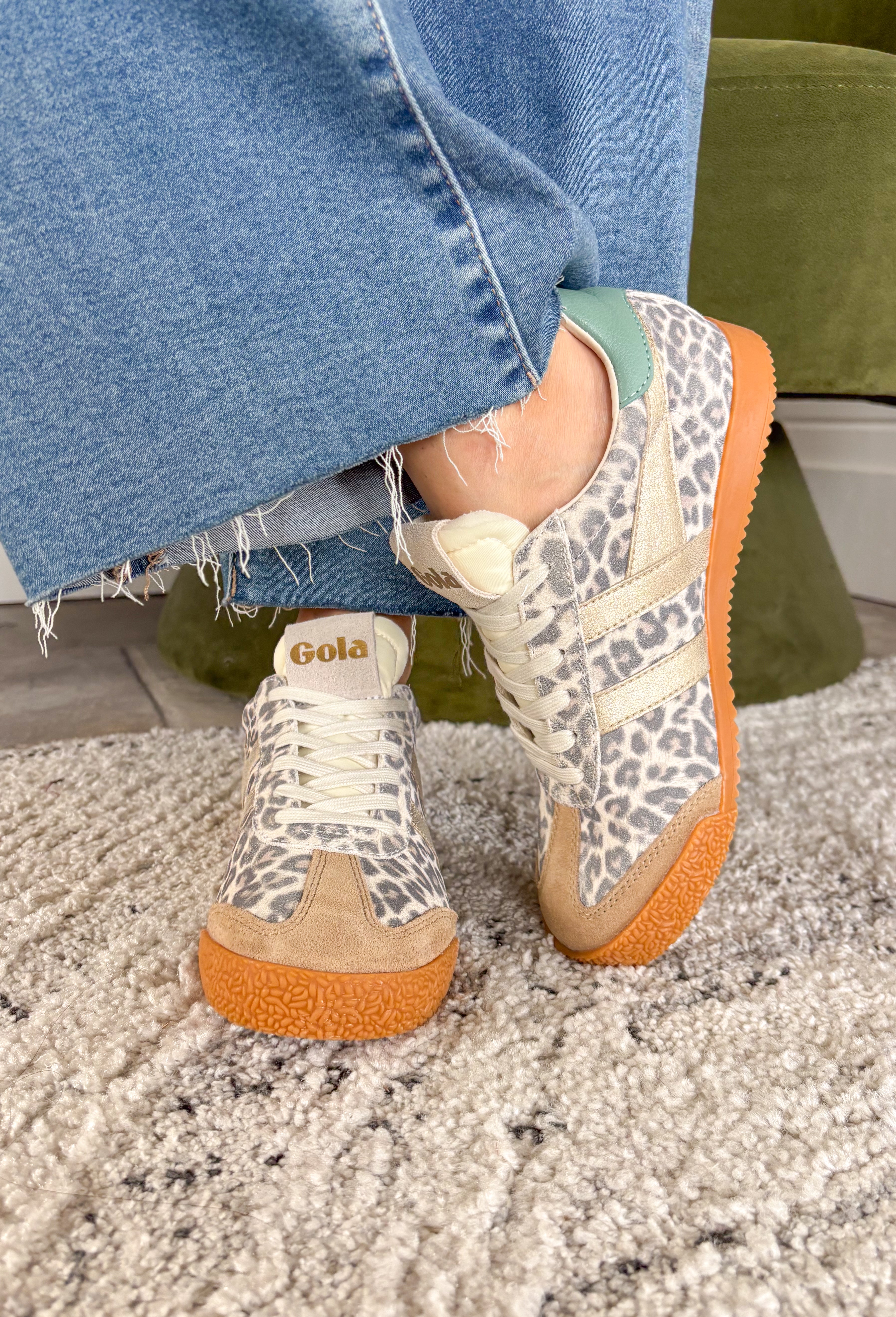 A fan favorite with a bold new twist! The Gola Elan Safari sneaker brings a fresh update to a classic silhouette with its all-over snow leopard print suede. The rich mix of caramel, gold, and green tones adds warmth and dimension, making this pair a standout while still feeling easy to style. Blending heritage-inspired design with a modern edge, this sneaker delivers both comfort and personality. 