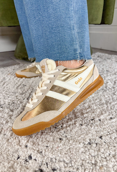 A fresh take on your everyday sneaker! The Gola Firefly Metallic brings just the right amount of shine with its striking gold finish, perfectly balanced by neutral suede and soft off-white accents. It’s eye-catching without feeling over the top—making it easy to style for everyday wear. Blending classic design with modern detail, this sneaker delivers that polished, put-together look while still keeping things comfortable and casual. 