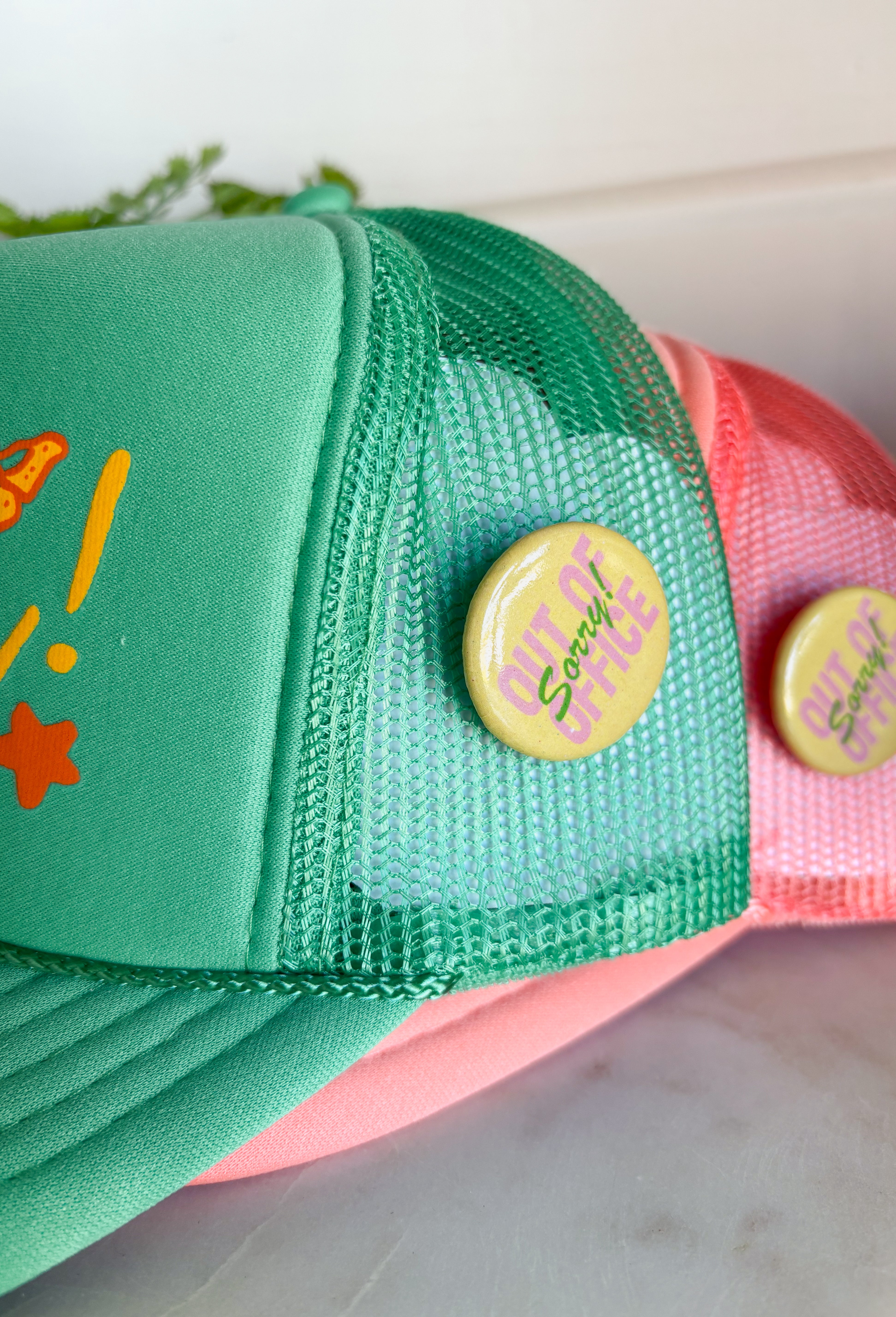All the good vibes in one hat! This green trucker hat features “Have A Nice Day!” in a warm mustard tone, surrounded by playful orange and mustard butterflies and star details for the happiest little pop of personality. A small yellow button on the side that reads “Sorry Out of Office” adds a fun, laid-back touch that makes this hat even more unique. With a breathable mesh backing and adjustable fit, it’s perfect for sunny days, weekend plans, or anytime you're in your carefree era.