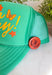 All the good vibes in one hat! This green trucker hat features “Have A Nice Day!” in a warm mustard tone, surrounded by playful orange and mustard butterflies and star details for the happiest little pop of personality. A small rust button on the side with a horse shoe design adds a fun, laid-back touch that makes this hat even more unique. With a breathable mesh backing and adjustable fit, it’s perfect for sunny days, weekend plans, or anytime you're in your carefree era.
