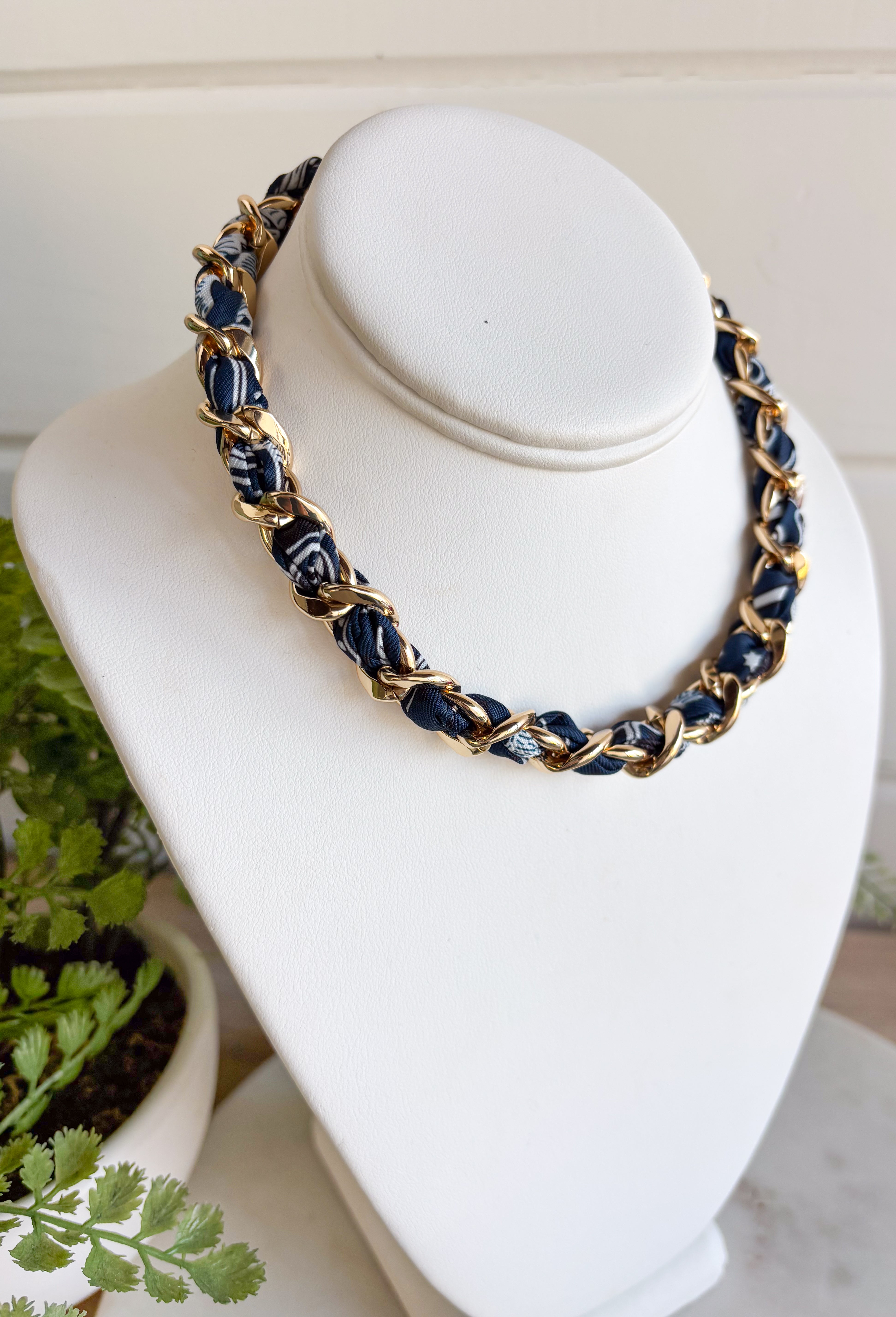 Add a bold yet timeless touch to your look with this navy bandana and gold chain necklace. The chunky gold chain is threaded with a navy bandana, creating the perfect mix of edgy and chic. Whether you’re dressing up for a night out or keeping it casual with a tee and jeans, this statement piece brings effortless style to every season.