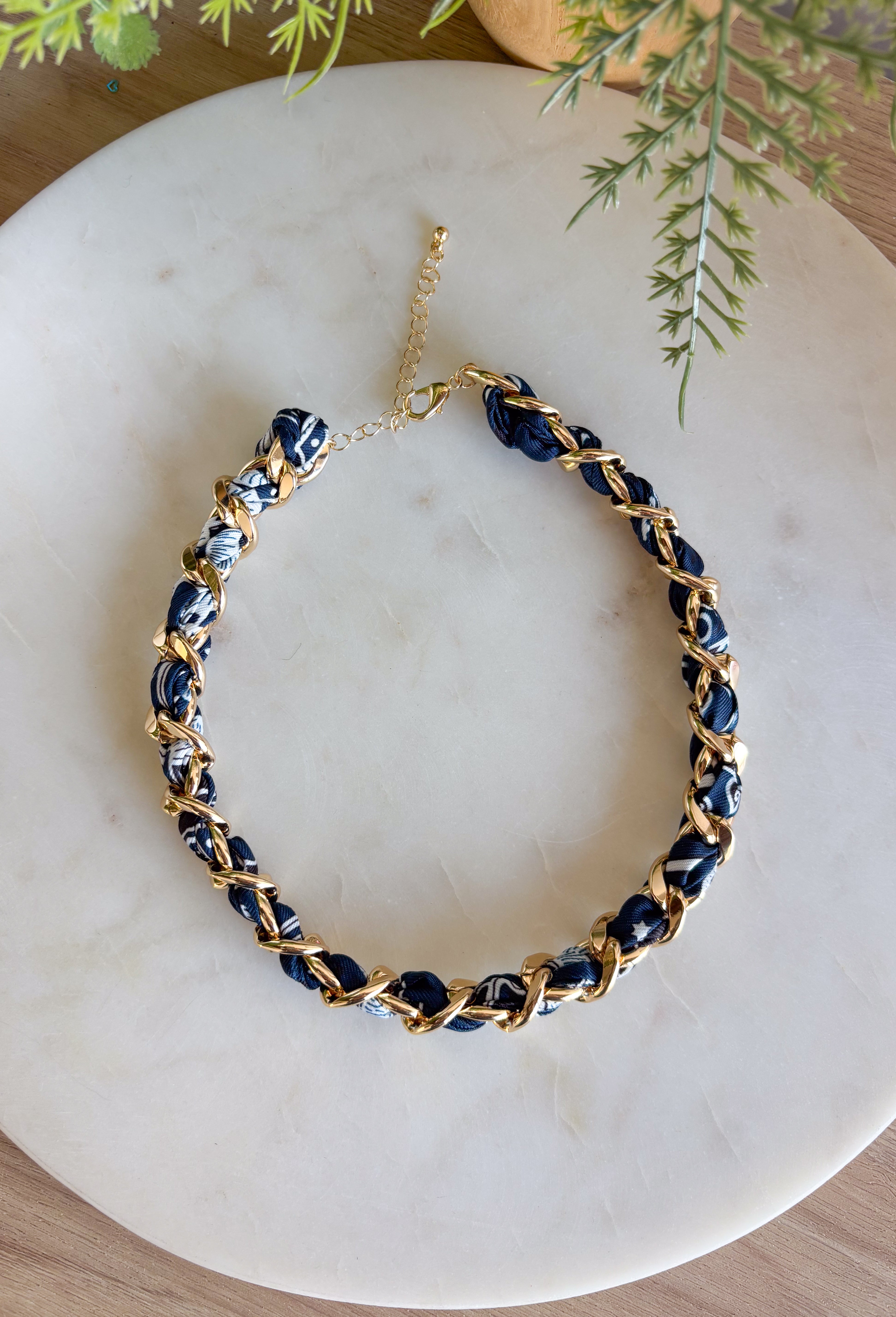 Add a bold yet timeless touch to your look with this navy bandana and gold chain necklace. The chunky gold chain is threaded with a navy bandana, creating the perfect mix of edgy and chic. Whether you’re dressing up for a night out or keeping it casual with a tee and jeans, this statement piece brings effortless style to every season.