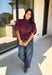 Rich burgundy and pretty shaping details make this top from Entro an easy pick for fall. The button-front design keeps the look classic, while a pleated waist and self-tie detail create a flattering shape that gives the silhouette a little something extra. Short puff sleeves add soft volume and balance out the fitted waist beautifully. Made from a cotton-blend fabric with a touch of stretch, it’s comfortable enough for all-day wear while still looking put together. 
