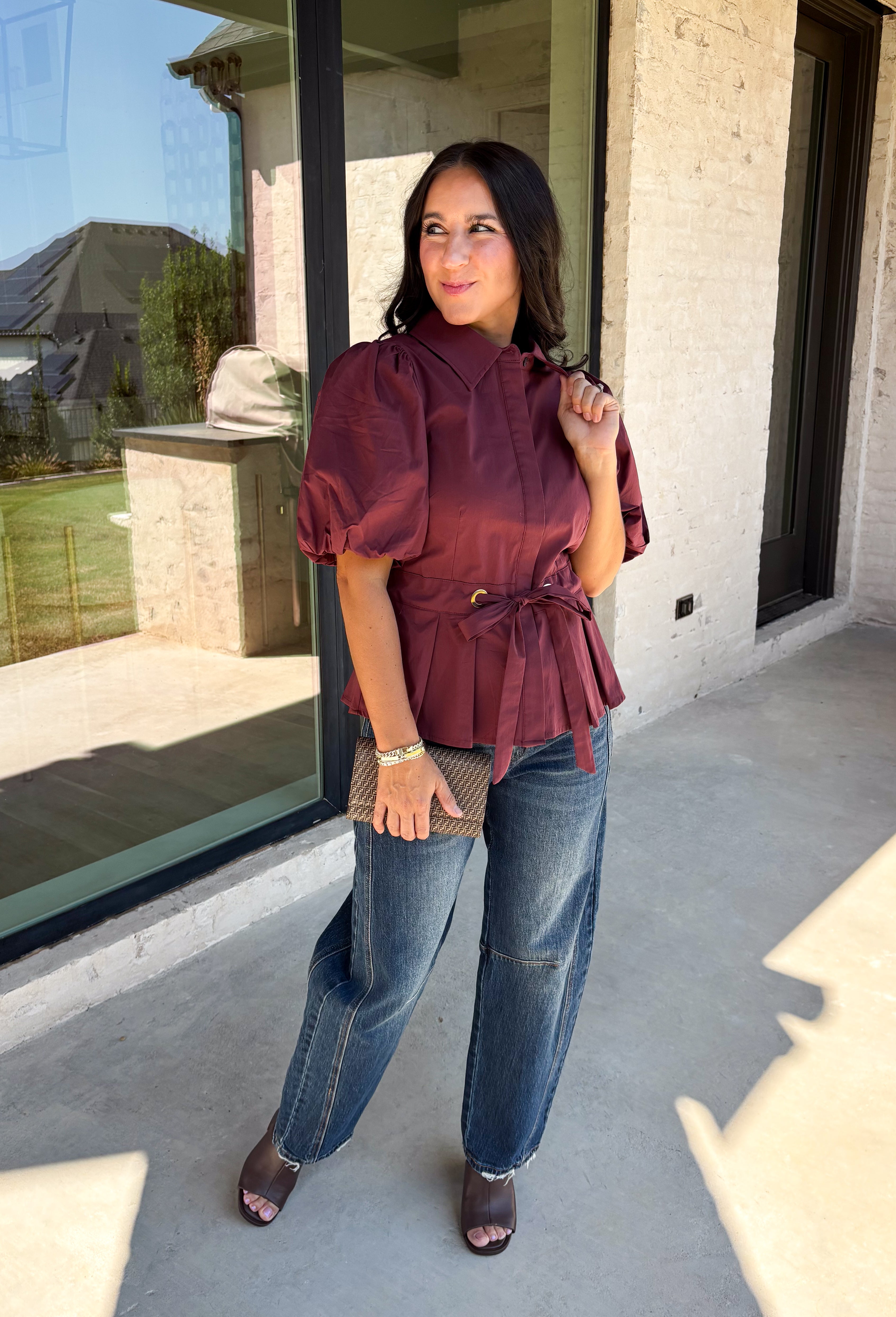 Rich burgundy and pretty shaping details make this top from Entro an easy pick for fall. The button-front design keeps the look classic, while a pleated waist and self-tie detail create a flattering shape that gives the silhouette a little something extra. Short puff sleeves add soft volume and balance out the fitted waist beautifully. Made from a cotton-blend fabric with a touch of stretch, it’s comfortable enough for all-day wear while still looking put together. 