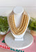 Add a pretty pop of gold to your look with this eye-catching layered beaded necklace. Featuring seven strands of gold beads, this chunky statement piece creates a full, dimensional look that makes even the simplest outfit feel a little more fun. The faux leather backing helps keep each layer beautifully arranged, while the magnetic closure makes it easy to put on and take off. It’s the perfect finishing touch for sweaters, dresses, blouses, and everyday basics.