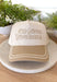 This neutral trucker hat with tan accents is a must-have for all the iced coffee lovers out there. Featuring “Iced Coffee Connoisseur” embroidered across the front, it adds a fun, laid-back touch to your everyday outfits. The neutral color palette keeps it easy to style, while the adjustable back offers a comfortable, custom fit for all-day wear. Perfect for coffee runs, casual days, and sunny spring outings, this hat is equal parts playful and practical.