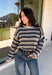 Wrap yourself in the colors of the season with this cozy open knit sweater from Hyfve. Featuring a beautiful stripe pattern in cream, tan, light blue, burgundy, hunter green, and dark blue, this timeless knit captures everything you love about fall. The lightweight open knit construction makes it perfect for layering on crisp mornings and cool evenings, while the relaxed silhouette keeps it effortlessly comfortable. 
