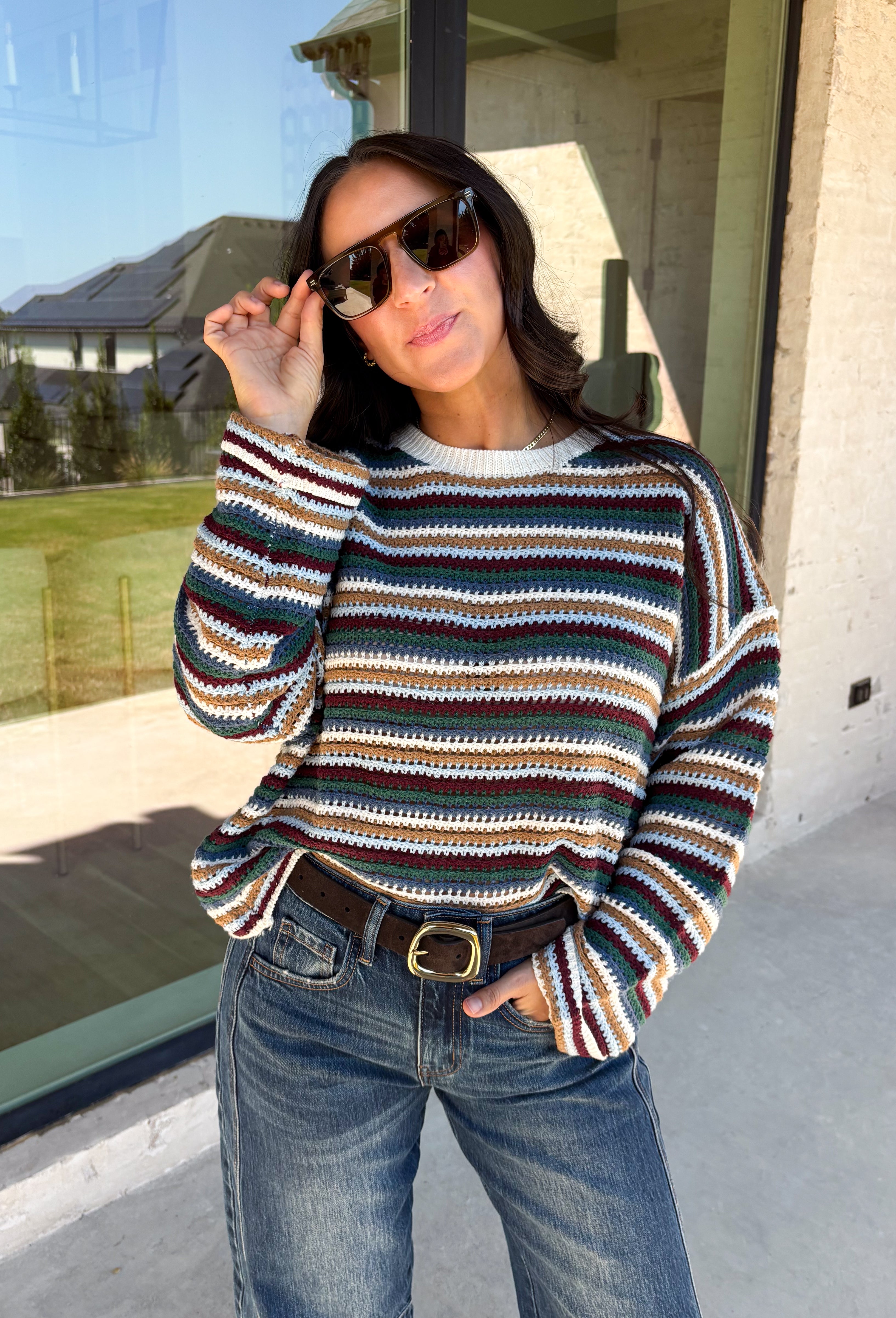 Wrap yourself in the colors of the season with this cozy open knit sweater from Hyfve. Featuring a beautiful stripe pattern in cream, tan, light blue, burgundy, hunter green, and dark blue, this timeless knit captures everything you love about fall. The lightweight open knit construction makes it perfect for layering on crisp mornings and cool evenings, while the relaxed silhouette keeps it effortlessly comfortable. 