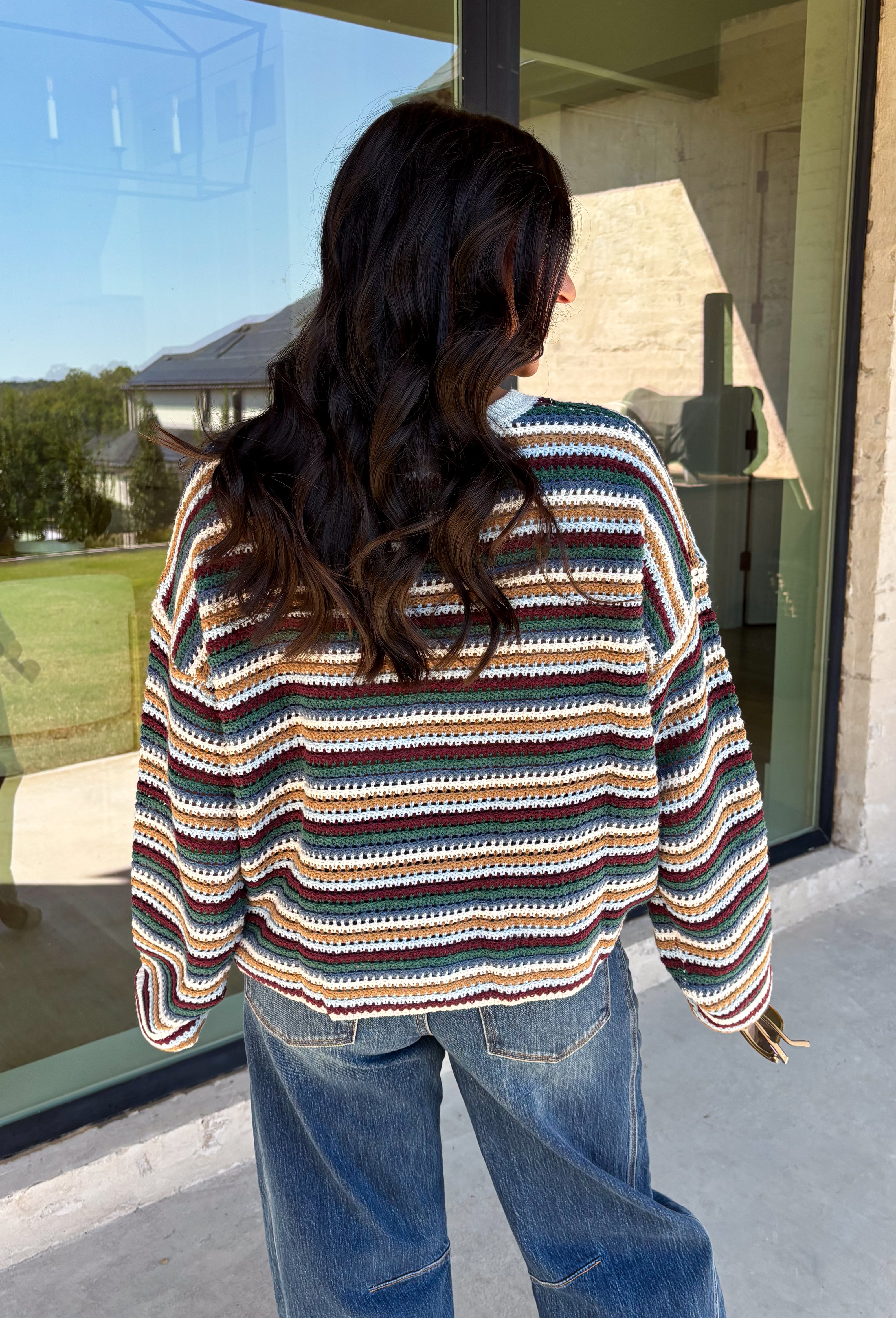 Wrap yourself in the colors of the season with this cozy open knit sweater from Hyfve. Featuring a beautiful stripe pattern in cream, tan, light blue, burgundy, hunter green, and dark blue, this timeless knit captures everything you love about fall. The lightweight open knit construction makes it perfect for layering on crisp mornings and cool evenings, while the relaxed silhouette keeps it effortlessly comfortable. 