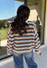 Wrap yourself in the colors of the season with this cozy open knit sweater from Hyfve. Featuring a beautiful stripe pattern in cream, tan, light blue, burgundy, hunter green, and dark blue, this timeless knit captures everything you love about fall. The lightweight open knit construction makes it perfect for layering on crisp mornings and cool evenings, while the relaxed silhouette keeps it effortlessly comfortable. 