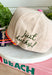 Add a playful outdoor-inspired touch to your everyday look with this unique trucker hat. Featuring a neutral faux suede front and a camouflage bill, this standout style is embroidered with a detailed mallard design accented by pink and orange stitching for an unexpected pop of color. The side is embroidered with "Just Ducky," while the back features "It's A Good Life" in olive green, giving this hat personality from every angle. 