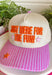 Bring a little extra fun wherever you go with this playful trucker hat! Featuring "Just Here For The Fun" embroidered in bright orange, this hat is made for football Saturdays, fall festivals, road trips, and spontaneous adventures. The pink bill with neutral stripes adds the perfect pop of color, while the light pink and orange embroidered stars give it a cheerful finishing touch. 